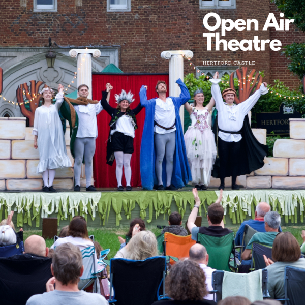 Visitors watching open air theatre performance at Hertford Castle 