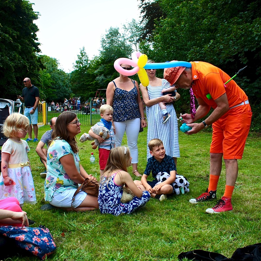 Children watching man balloon modelling